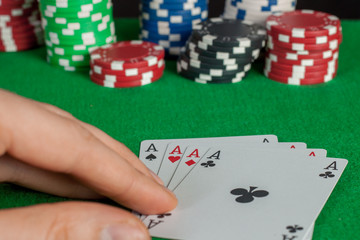 Four Aces and poker chips stack on green table