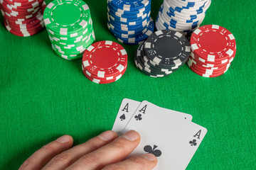 two Aces and poker chips stack on green table