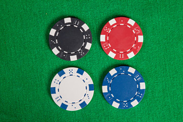 Four macro poker chips on green table