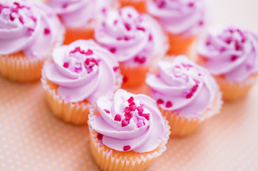 Cupcakes with pink cream and heart sprinkles