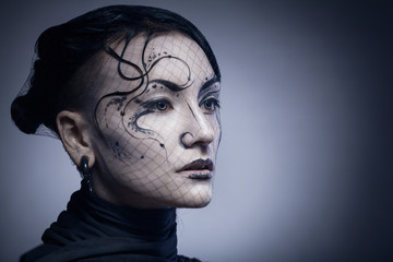 portrait of young gothic woman isolated on dark background with