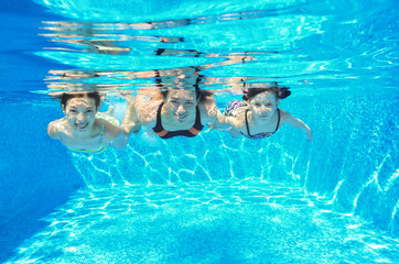 Happy family swim underwater in pool and having fun