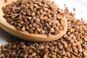 Buckwheat seeds on wooden spoon in closeup