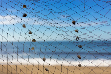 fishing net on beach, sea and sky at background