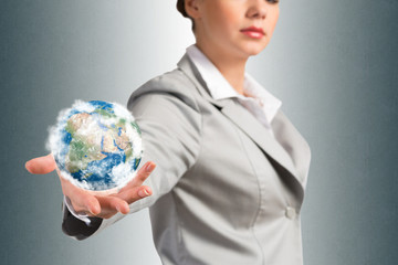 businesswoman holds up a planet Earth