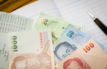 Thai banknotes on book bank and account book background