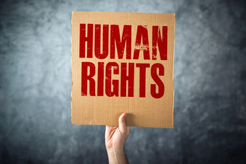 Man holding cardboard paper with HUMAN RIGHTS title - obrazy, fototapety, plakaty