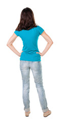 back view of standing young beautiful  brunette woman in jeans.