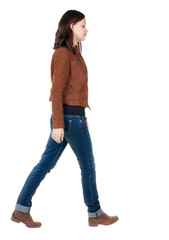 back view of walking  woman in brown jacket.