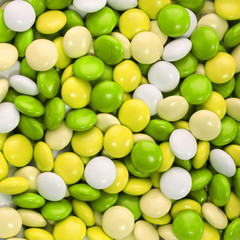 Fototapeta na wymiar . Cukierki czekoladowe pokryte żółty, zielony i biały Tło