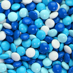 Chocolate candy coated in blue and white. Background