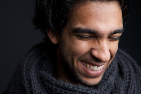 Young man laughing with gray scarf