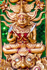 Fototapeta na wymiar Ancient golden carving wooden window of Thai temple. Thailand
