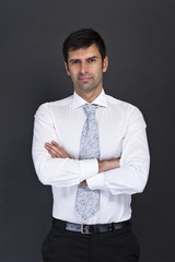 businessman standing on grey background with crosed arms