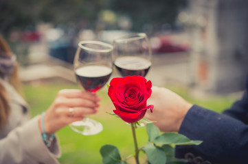 close up a single rose with a coule drinking wine