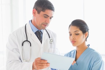 Fototapeta premium Doctor and nurse discussing over digital tablet