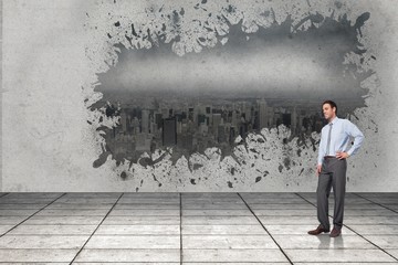 Composite image of smiling businessman with hand on hip