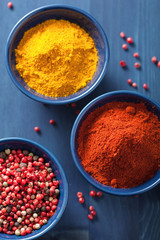 spices in bowls: curry pink and black pepper paprika powder