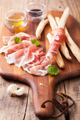 italian prosciutto ham grissini bread sticks olive oil