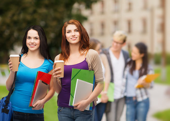 two students with bag, folders, tablet and coffee