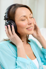 Naklejka premium smiling woman with headphones at home