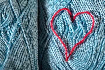 Knitted red heart on blue
