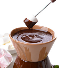 Chocolate fondue with marshmallow candies, isolated on white