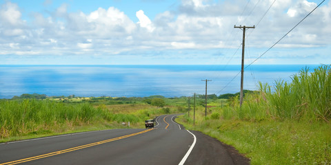 Fototapeta na wymiar Puste drogi w hawajskiej wsi z samochodu i Oceanu w backgro