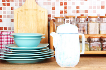 Tableware in kitchen on table on mosaic tiles background