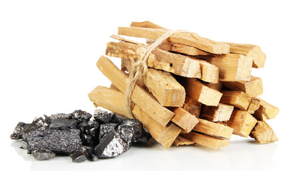 Stack of firewood and heap of coal isolated on white