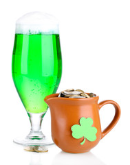 Glass of green beer and pitcher with coins isolated on white