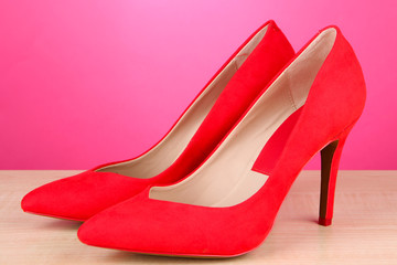 Beautiful red female shoes, on pink background