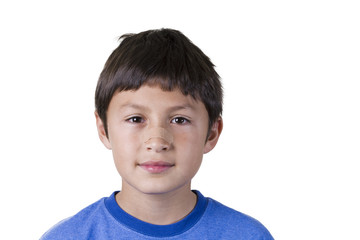 Young boy with plaster on his nose - on white background
