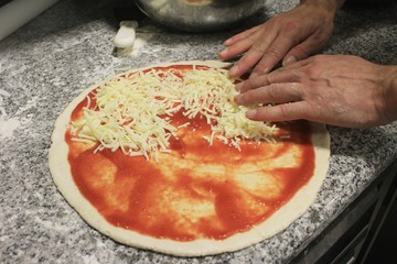 chef preparing pizza in kitchen