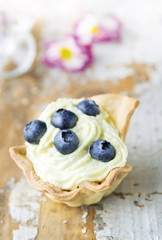 Bilberry tart with Cheese cream on old blu wood board