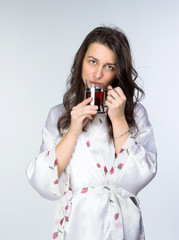 Woman with cup of tea  in peignoir early morning