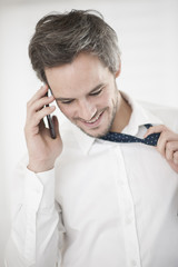 businessman at phone take off his tie