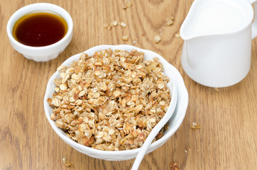 homemade muesli, jug of milk and a bowl of honey for breakfast
