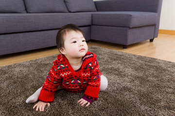 Asian little girl crawling on carpet and looking up