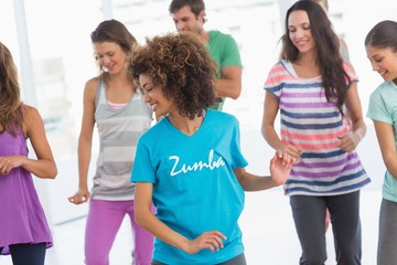 Fitness class doing pilates exercise in bright room