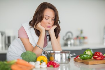 Obraz na płótnie Canvas Serious woman preparing food in kitchen
