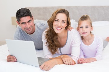 Fototapeta na wymiar Family with laptop in bed