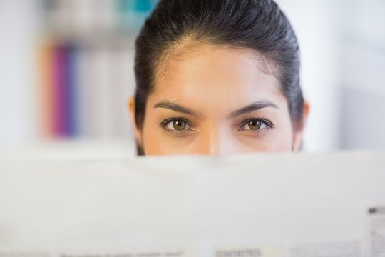 Businesswoman Peeking Over Newspaper