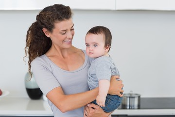 Smiling mother carrying baby