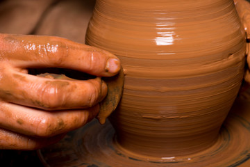 hands of a potter, creating an earthen jar