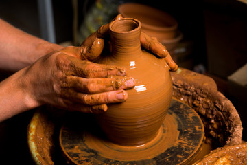 hands of a potter, creating an earthen jar