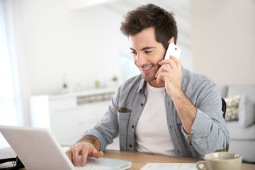 Salesman working from home and talking on phone