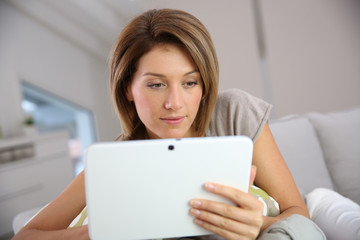 Cheerful woman at home using digital tablet