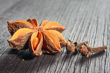 Anise stars and cloves on wooden background