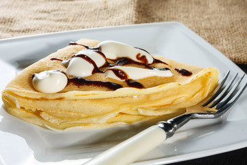 crepe with whipped cream and chocolate sauce